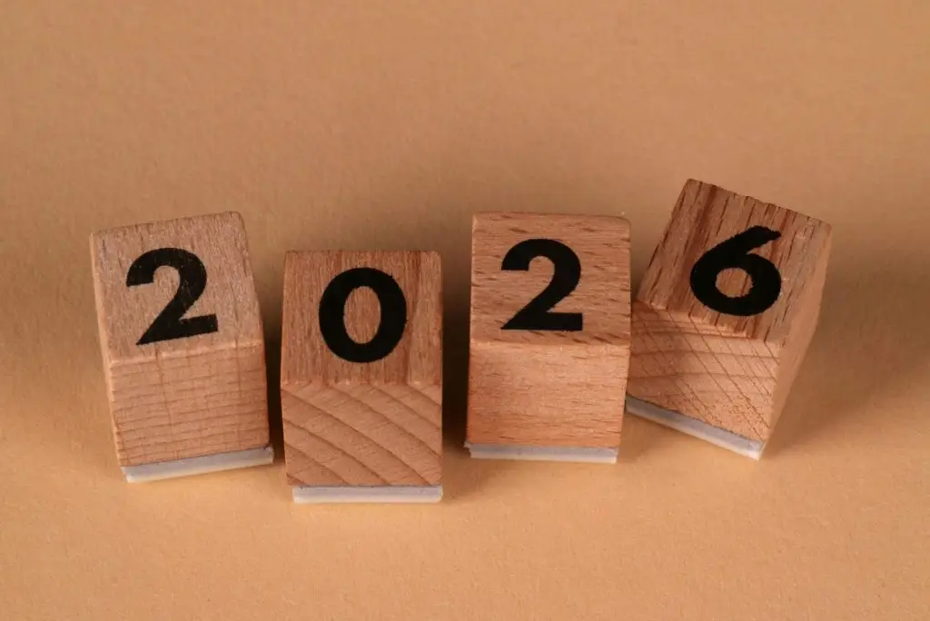 Wooden blocks forming the number 2026 on a beige background, representing the year 2026.